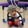 Child with cerebral palsy using a "smart onesie" a complex device with brain and body sensors.