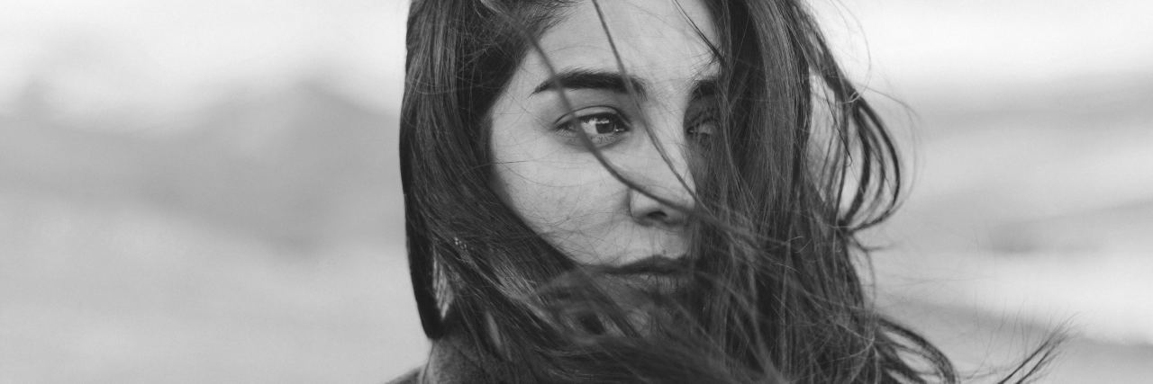 What It's Like to Live With Ehlers-Danlos Syndrome When You're Young close-up of woman's face with hair blowing in the wind