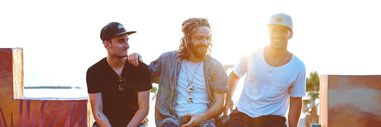 You Should Not Censor Your Mental Illness for Other People 3 men sitting on a ledge smiling and hanging out
