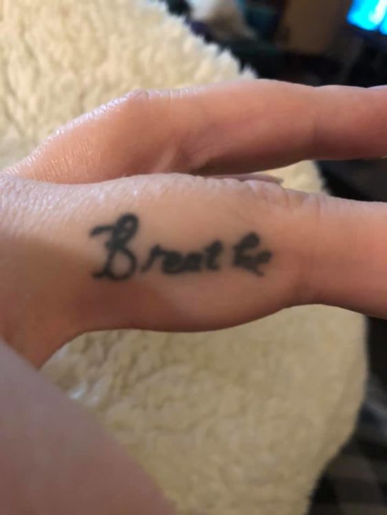Jennifer shows the viewer her finger, where the word 'Breathe' is written in cursive.