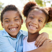 Two young African-American children smiling.
