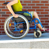 Woman pushing herself in wheelchair.