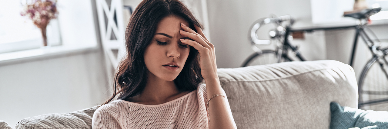 Everything You Need to Know About the Botox Letdown Woman holding her head with her hand as if in pain
