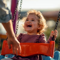 Adorable little girl having fun on a swing.
