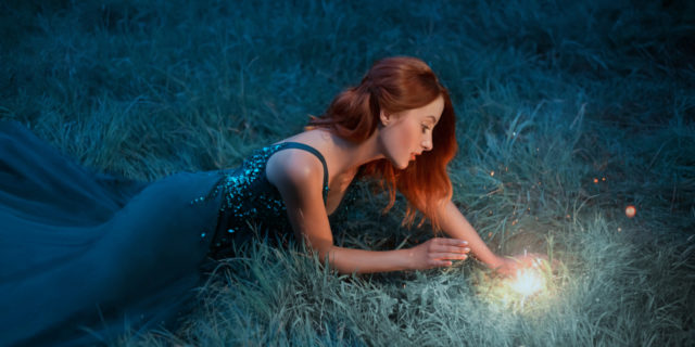 Woman finding a light in a dark field.
