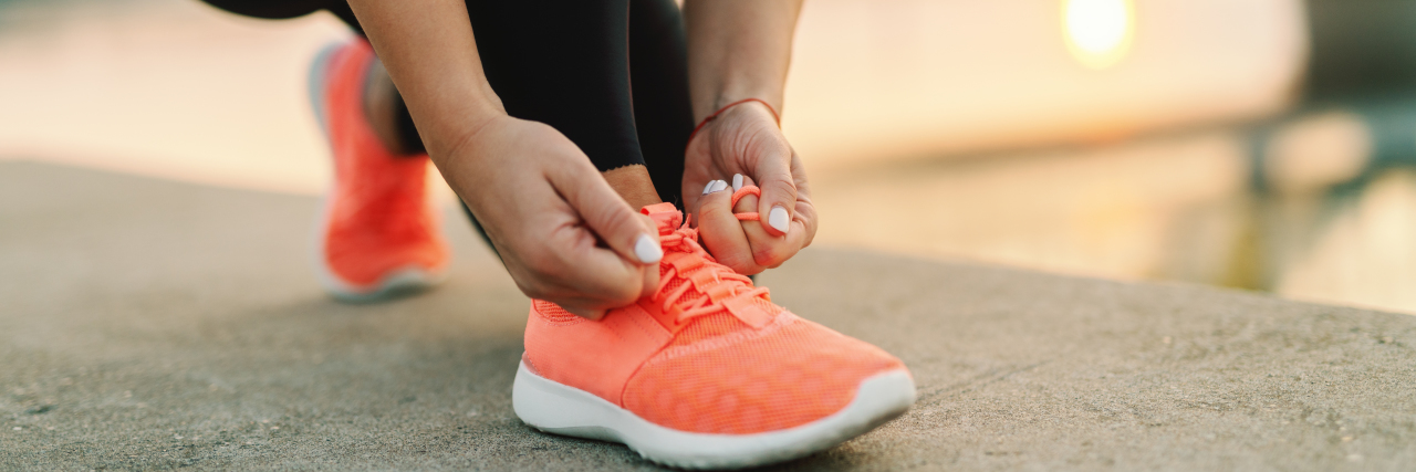 What to Know: Exercising With a Heart Disease Close up of sporty woman tying shoelace while kneeling outdoors