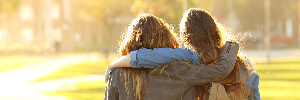 Things Not to Say to Someone with PTSD friends walking at sunset in a park with their arms around each other