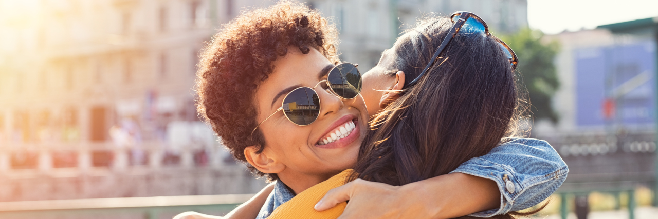 How to Support Your Best Friend With a Chronic Illness Two friends hugging in the street.