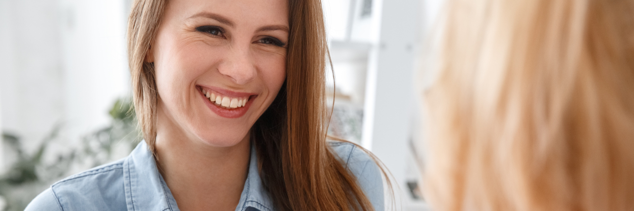 Why Talking With a Therapist Can Help With Chronic Illness photo of therapy client smiling and talking with her therapist