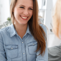 photo of therapy client smiling and talking with her therapist