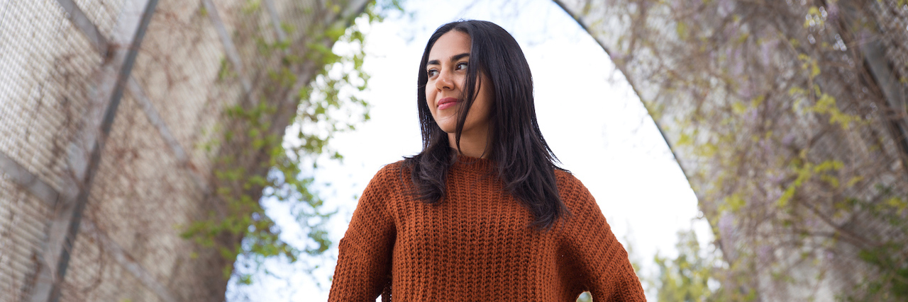 Learning to Truly Love Myself by Going Beyond Basic Acts of Self-Care Pensive young woman walking in park.