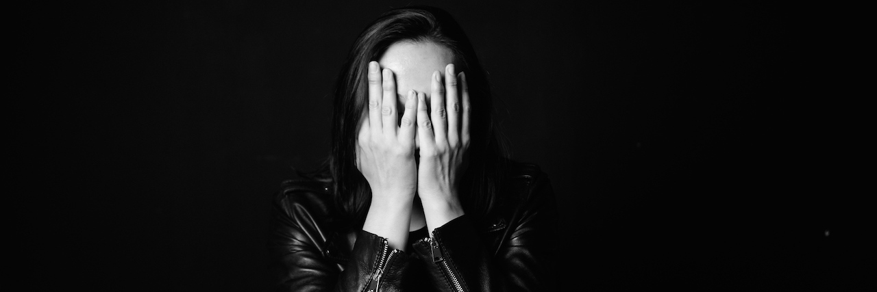Living with the Anger and Irritability from PTSD Portrait of a woman in a leather jacket with her hands over her face