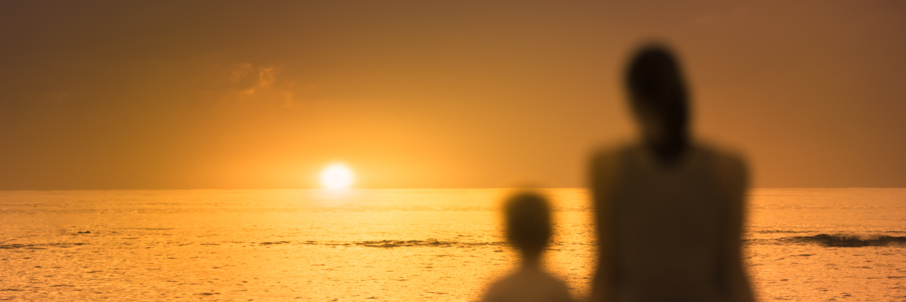 Parenting With Parkinson's Disease Mother and child sitting together watching the sunset.