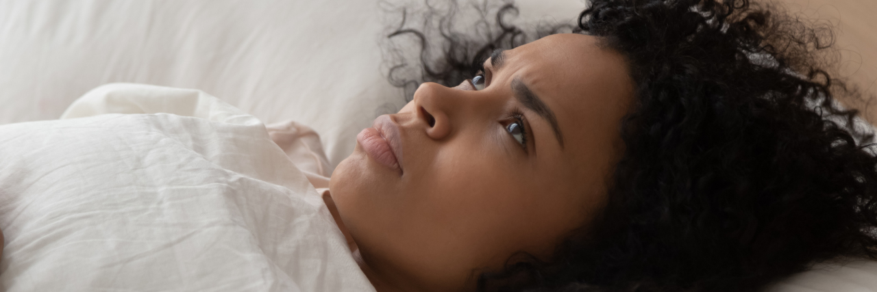 How It Feels to Live With Constant, Chronic Pain Woman lying in bed with pain.