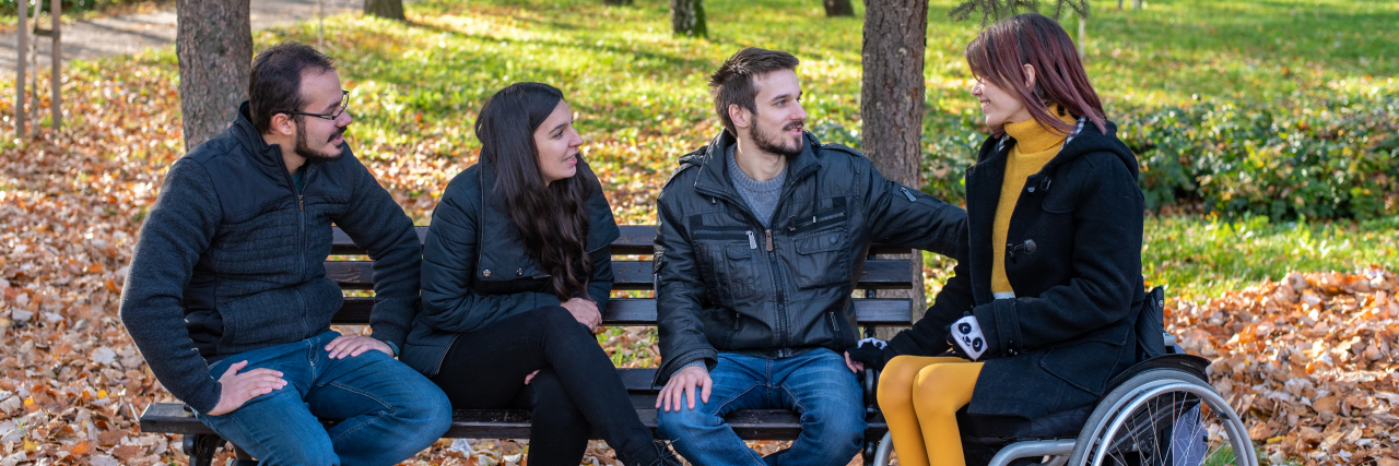 How to Avoid Ableism and Be an Ally to People With Disabilities Young disabled woman in a wheelchair with friends in a park.