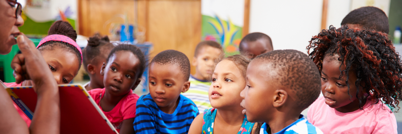 Teacher reading a book with a class of preschool children.