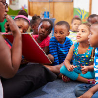 Teacher reading a book with a class of preschool children.