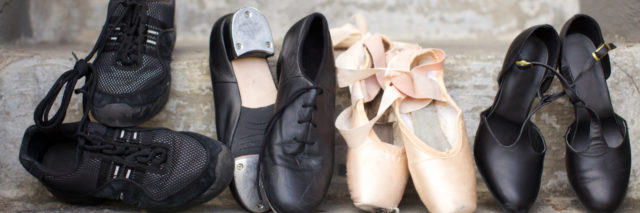 Closeup of a pair of jazz shoes, tap shoes, ballet pointe shoes, and character shoes.