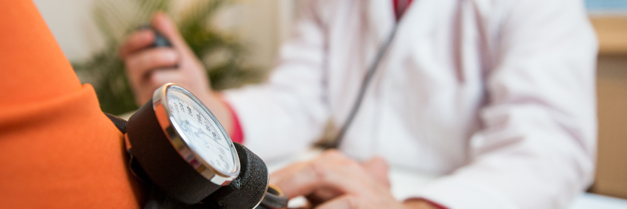 What You Need to Know About Recovering From a Stroke Male doctor holding hand of patient with blood pressure cuff in hospital.