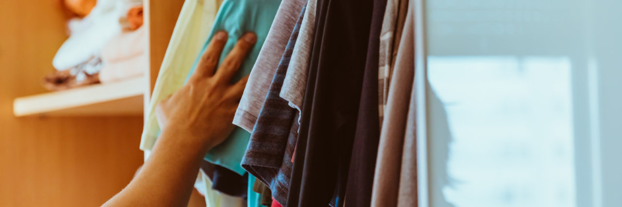 a man's hand searching through a closet