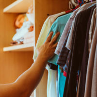 a man's hand searching through a closet