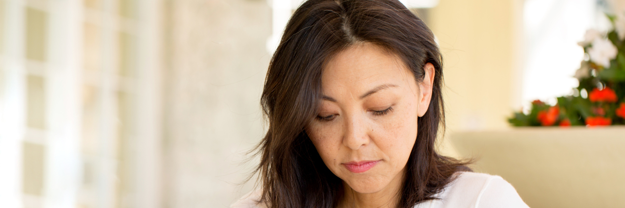 How I Explain What Fibromyalgia Feels Like Tired woman looking down at coffee cup.