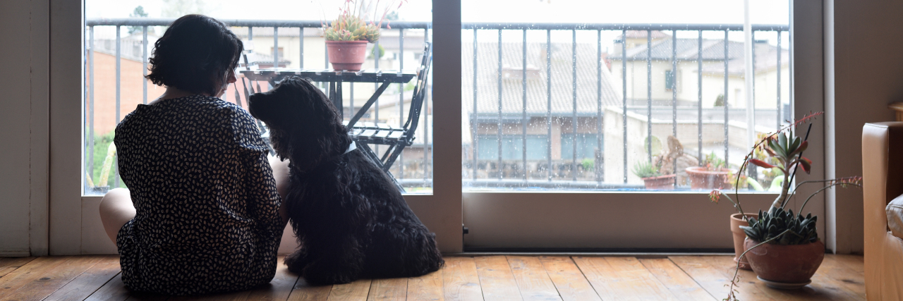 'Ugly' Sides of Epilepsy Most People Don't Like Talking About a woman is sitting on the floor with her dog looking sad