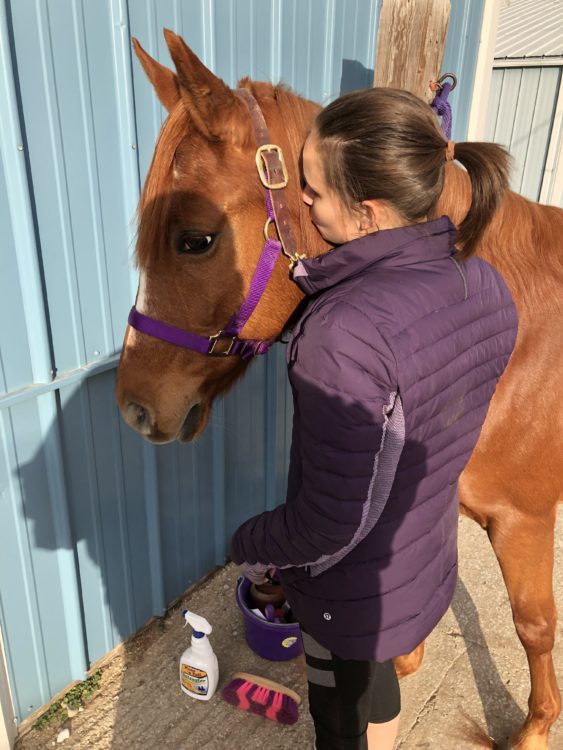 the author giving a kiss to her horse