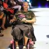 A woman in a wheelchair on a fashion runway.