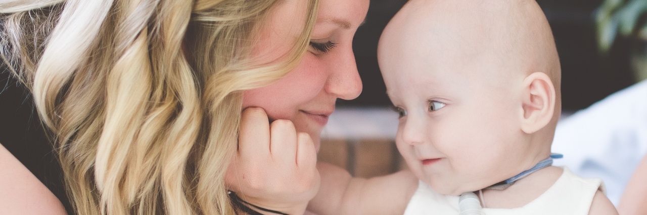 The Difficult Decision We Faced While Our Mico Preemie Was in the NICU a mother smiling at her infant daughter and holding her hand