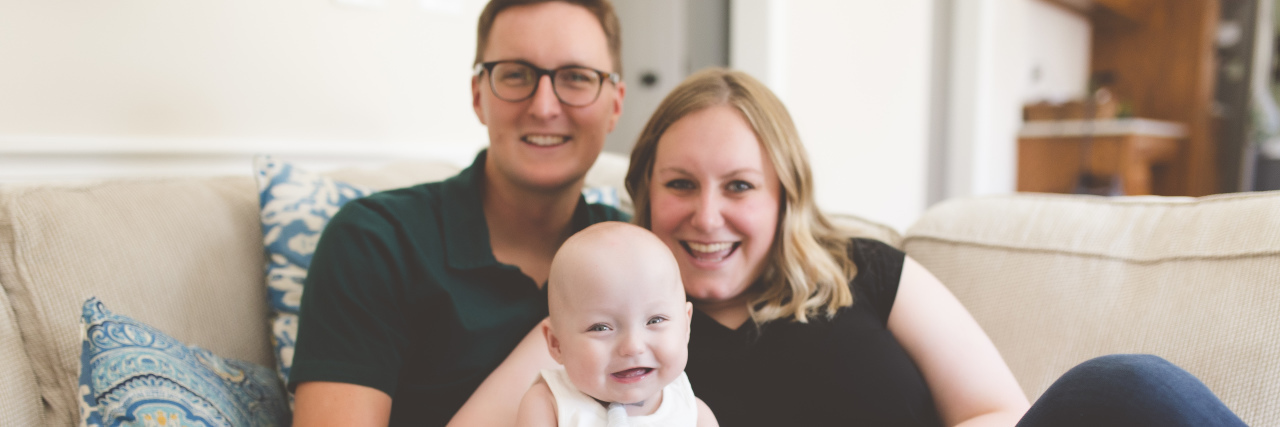 Why I Live in Quarantine With My Micro Preemie During Flu Season babygirl sitting on her parents' lap