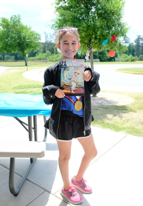 Izzy from Marvel's Hero Project holding her comic book