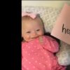 A babygirl with Down syndrome laying in a boppy with a sign that says "I am heavensent."