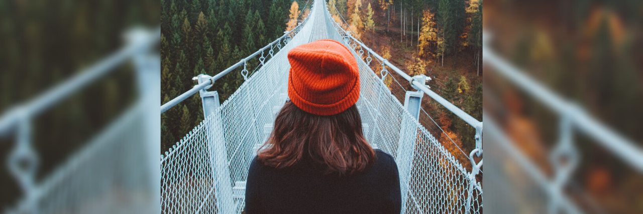 What to Know if You're Afraid of Obstacles in Eating Disorder Recovery photo of woman on footbridge crossing over chasm and trees in distance