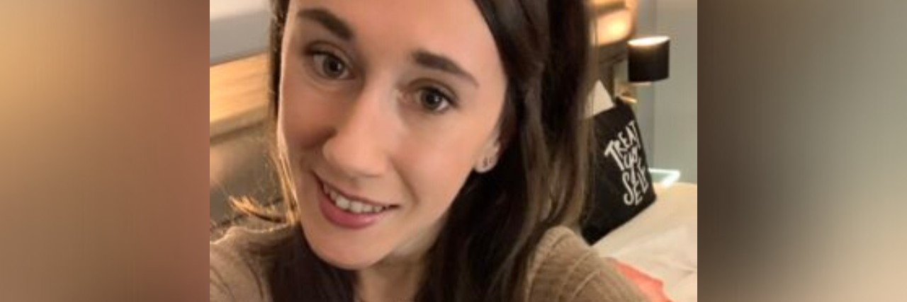 I'm Not on 'Vacation' Because I Can't Work Due to My Chronic Illnesses selfie of author, young woman in long brown hair smiling at camera