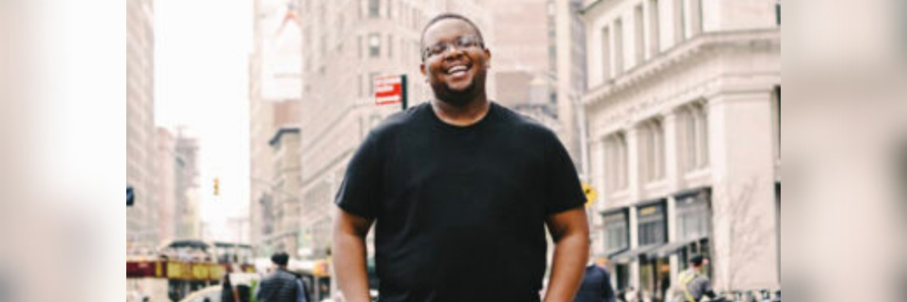 photo of author: happy black man smiling in the streets of a city
