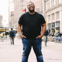 photo of author: happy black man smiling in the streets of a city