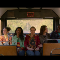 Scene from "Sex Education," young girls sit next to each other on the bus.
