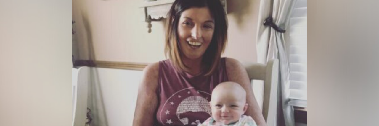 How Living Cautiously and Carefully With Scleroderma Saved My Life photo of author sitting on a chair, holding her newborn baby in her lap