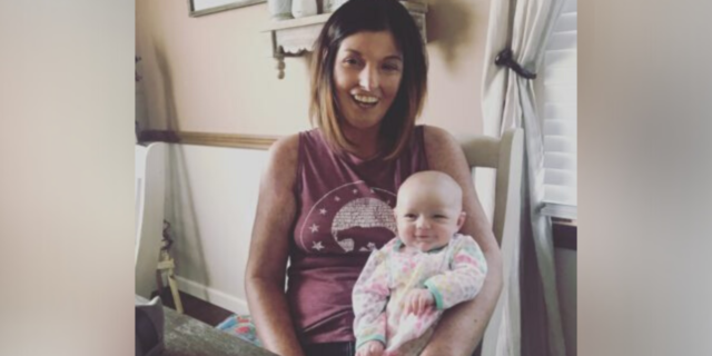photo of author sitting on a chair, holding her newborn baby in her lap