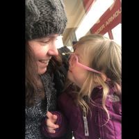 A mother smiling at her daughter with Down syndrome.