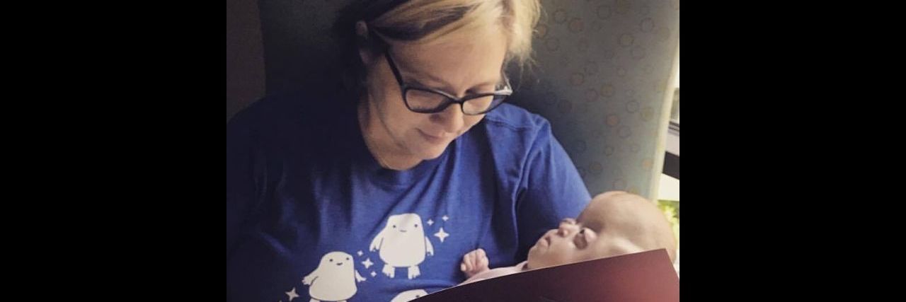 To the NICU Nurse Who Went the Extra Mile for My Daughter A mother cradling her baby and reading a book in the NICU.