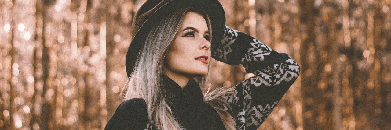 How to Recognize If You Have Depression and Anxiety photo of woman in woods wearing sweater and hat with hand raised to her hat