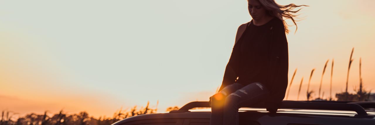 What to Know If You Feel Like Depression Will Never End photo of woman sitting on car at sunset looking down in thoughtfulness