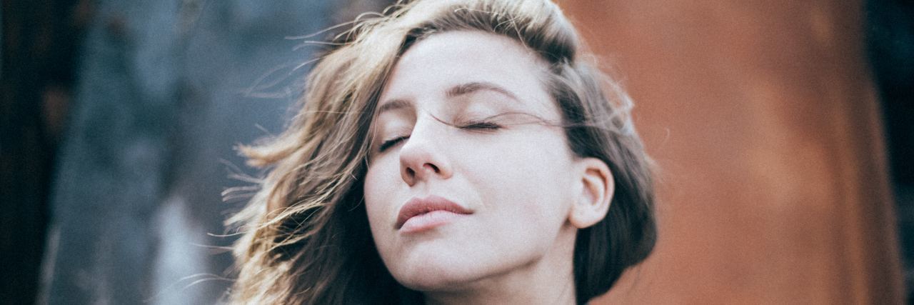 When Mental Health Insurance Coverage Is Harmful, Not Helpful woman outside with her eyes closed, embracing what's ahead