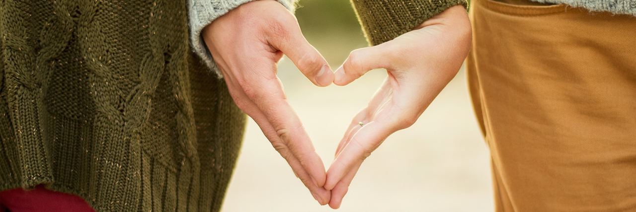 How My Chronic Illnesses and PTSD Affected My Engagement and Marriage couple making a heart with each of their hands