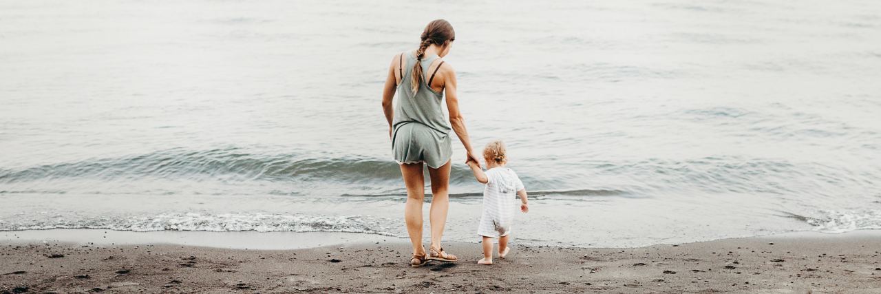 Fears About Being a Mother With Bipolar Disorder photo of a mother leading her young child to the water on a beach