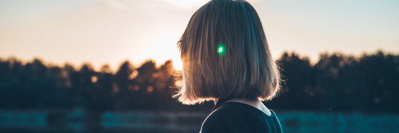How to Heal With Bipolar Disorder After a Divorce woman with short hair looking out at a lake at sunset