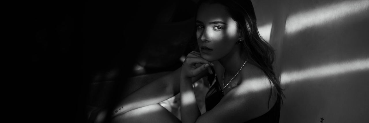 When You Have to Go Into Psychiatric Hospital but You're Scared black and white photo of woman sitting on floor looking into camera in dim light