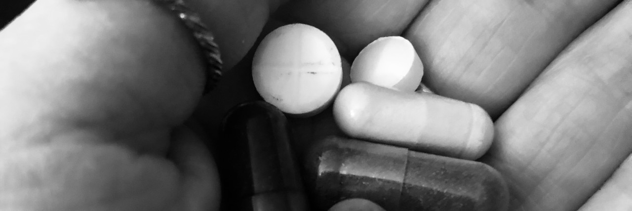 Please Don’t Feel Ashamed for Needing Medication Hand holding pills.
